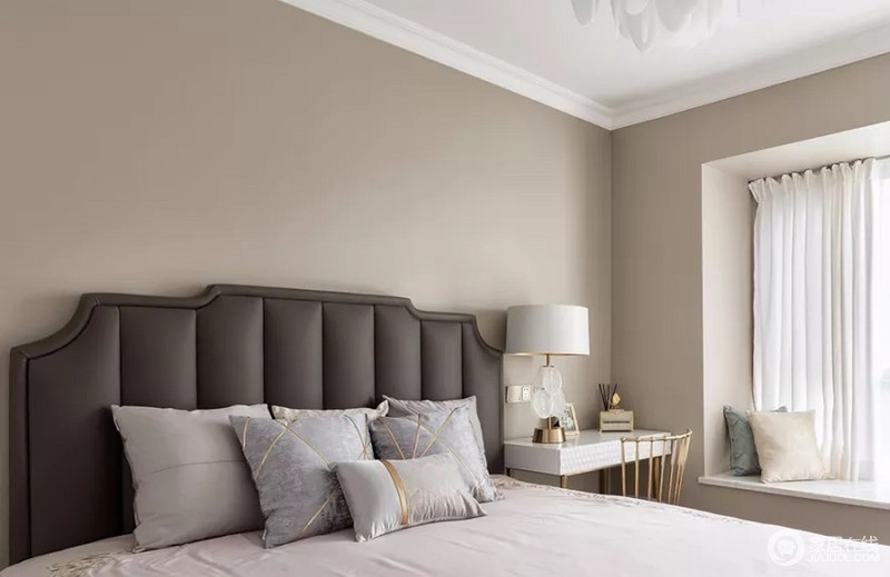 主卧用浅灰色墙面做背景，搭配深灰色雅致大床，加入少许金色元素带来高级感。