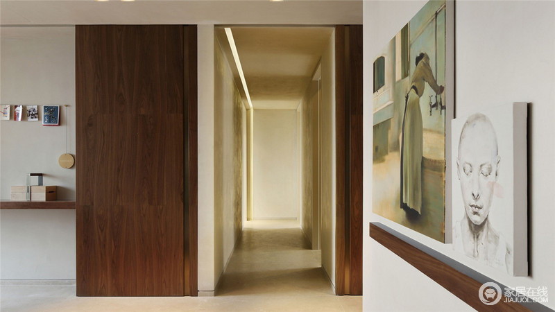 走廊的设计尤为简洁，从功能着眼，却利用木板与墙体统一线条来制成一个隐藏式收纳区，并借此来点缀空间的色彩；墙面上张贴着不同的艺术画，迥异之间，带着艺术令空间温文尔雅。