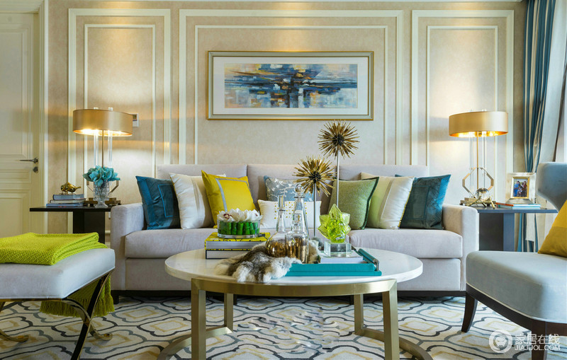 客厅色彩清幽柔和，淡灰色沙发搭配黄色、绿色、蓝色的靠垫色彩斑斓；金色铜质白理石桌和黑色边桌让空间质感纷呈，浅蓝色花纹地毯宁静中素雅。