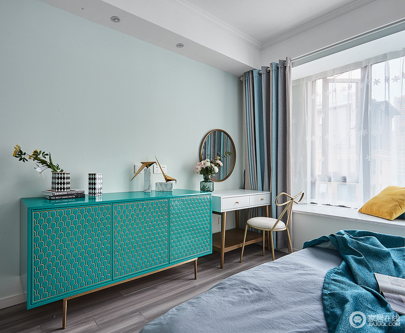 卧室淡蓝色粉刷墙面，柔和中多了色彩感，绿色鱼鳞纹理地边柜带着现代感让空间格外别致；黑白的器物更是添置了摩登，与简约地梳妆台构成卧室的小奢调。
