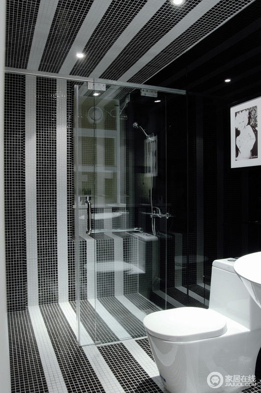 卫浴间采用马赛克打造出质感，黑白两色构成的条纹状演绎着时尚的家居设计之风，魔性十足；简约的设计利用玻璃门将干湿分区，功能性突出，质感生活就是用心的设计。