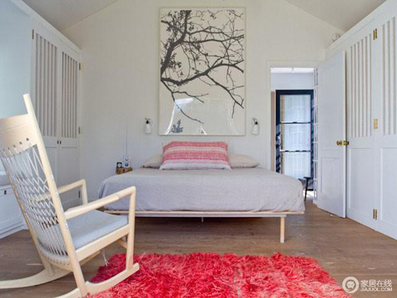 卧室以舒适为出，并没有太多的家具，单单以衣柜满足日常需要，格外宽敞，再加上锥字形吊顶，让挑高增加空间感；白色的空间因为原木地毯显出自然风，而墙上的墨画和实木摇椅让空间十分朴素安适，
红色毛绒地毯带来更丰富的色彩和更深层次的内涵，调剂出生活的平静与热情。