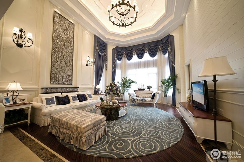 挑高、通透、明亮地空间与色彩忧郁地螺旋圆形地毯，在此基础上衍生出白色美式休闲风布艺沙发和藏蓝色罗马帘，使得整个客厅都变得活泼和时尚起来。