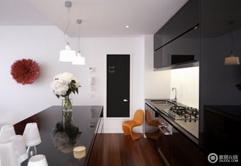 厨房的设计沿袭了主题，以黑白色酿造出空间的现代感；黑色整体橱柜与岛台相应相和与墙体立面构成对比，分离间又组合出不单调、有层次的空间。