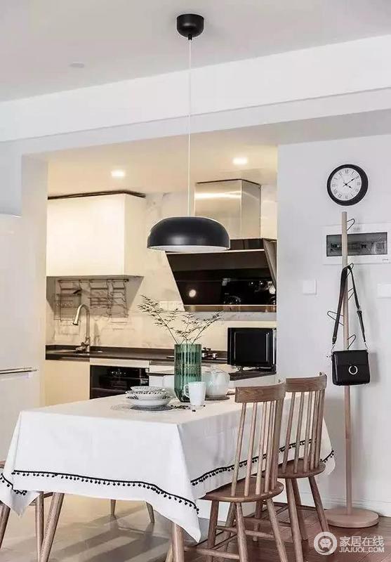为了房子不那么压抑，厨房做了半开放设计，整个空间采用黑、白、棕三色搭配，色彩过渡自然