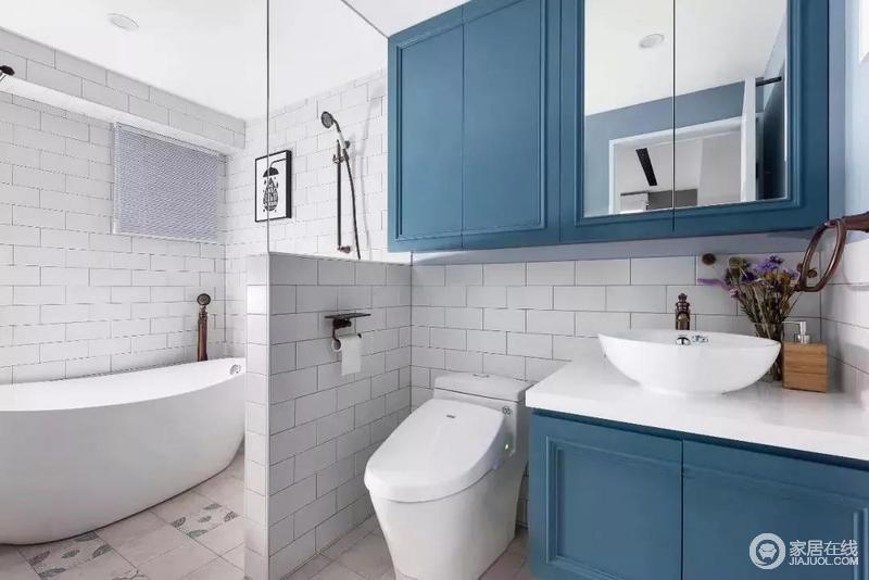 卫生间的干湿区用半矮墙＋半玻璃墙隔断区分，浴缸和淋浴区，满足主人不同的沐浴需求，而蓝色盥洗柜组合赋予空间海天一般的清雅。