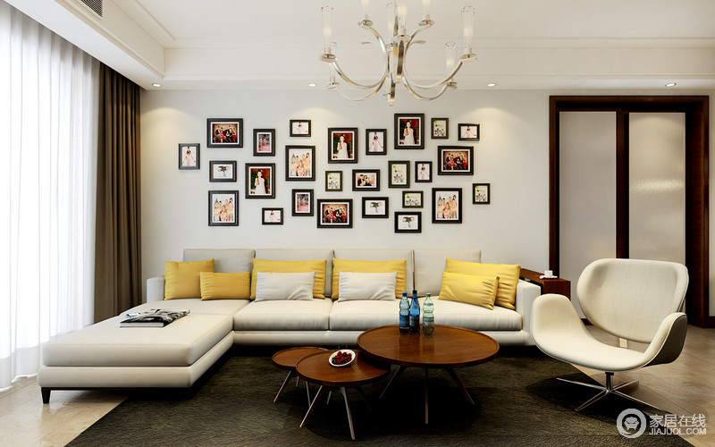 客厅中白色的墙面又黑框照片组成，记录了主人生活的点滴；白色沙发上黄色靠垫为空间增加了活力。