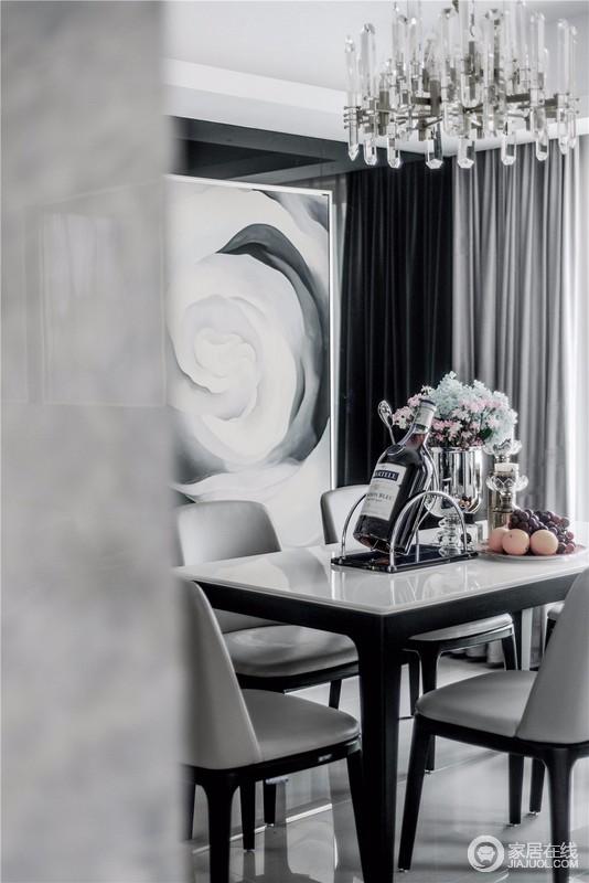 餐厅采用黑、白、灰永恒三色提升了整体空间的高级感。座椅造型简约、流光溢彩的顶灯与镜面玻璃交相辉映