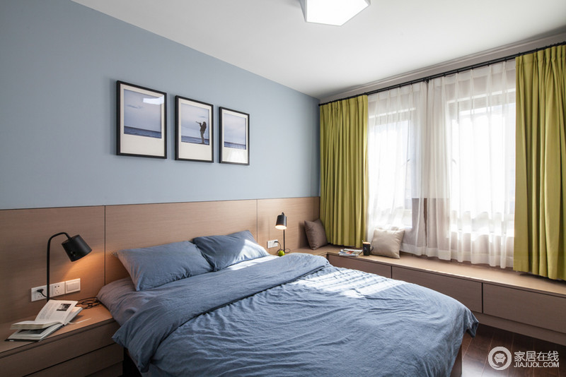 蓝色调的卧室里被灰蓝色床品的柔软打破沉静，幻化出低调的冷静；绿色窗帘裹挟着自然的天然和恬淡，令空间洋溢在宁静与生机中。
