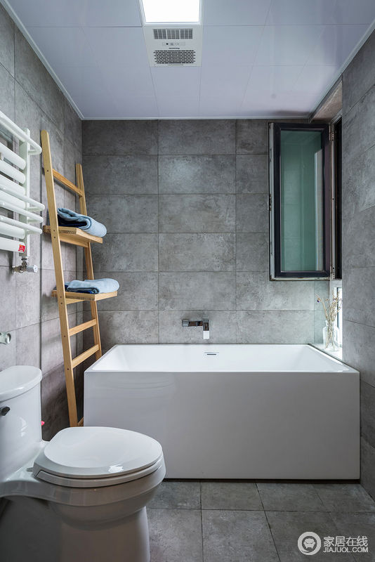 水泥瓷砖搭配白色卫浴洁具，朴质又显得素雅；原木色梯子置物架，让空间功能性增强且不再单调。
