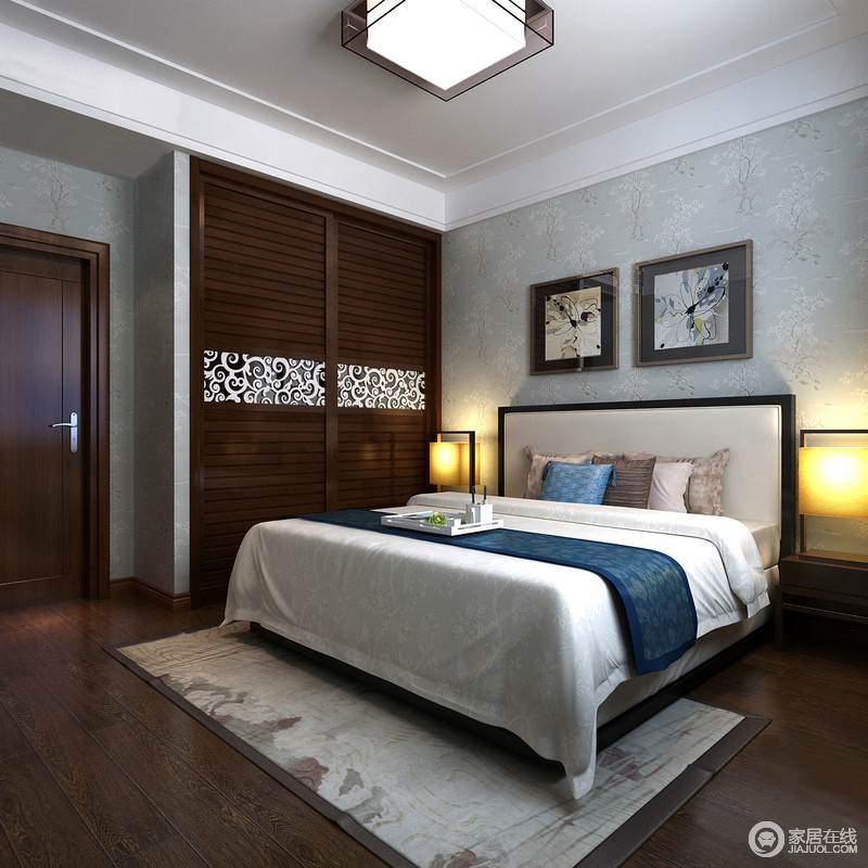 卧室的背景墙以浅蓝色花卉壁纸为主，与白色床品构成清新、舒雅；木质螺纹地板、山水图案地毯、橘色床头灯让冷调淡去，增加和谐。