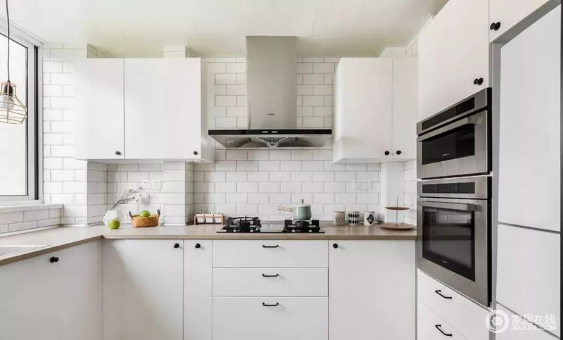 U型厨房最大化的利用空间，整体延续公领域的白色基调，定制橱柜嵌入大型厨电，空间简约整洁。