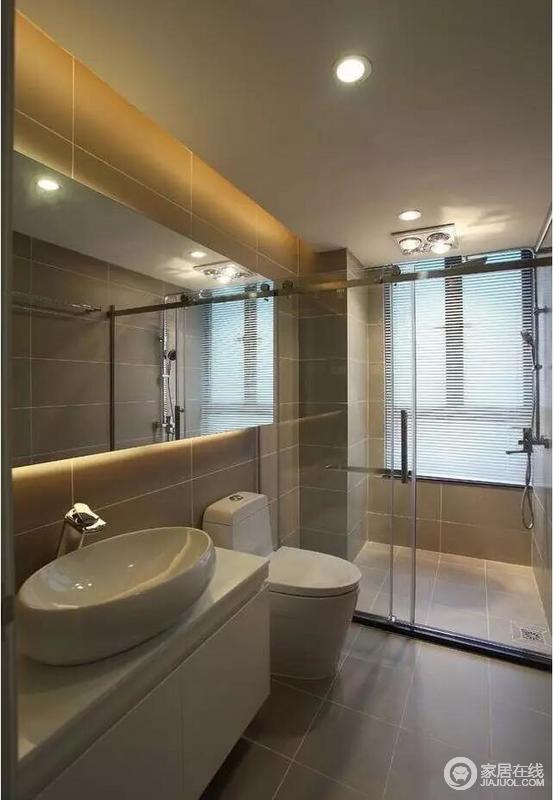 卫浴色彩统一，浅灰色的砖石铺贴出利整和素静，再加上玻璃淋浴房就干湿分区，线条流畅，易于打理；镜面柜提亮空间的同时，具有收纳功能。