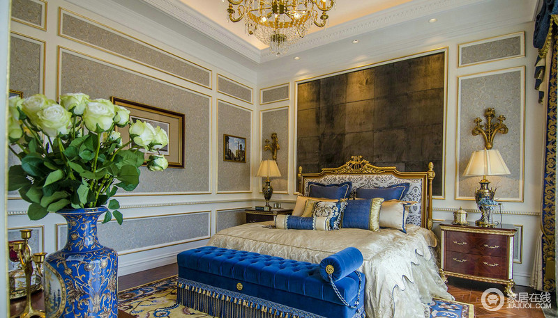 卧室大床设计很有特色，金属雕刻的工艺也成为了一种华丽的代言，原木的背景墙与浅灰色壁纸带着不一样的冷色调，让家不缺少层次；再加上墙面的几何效果，与蓝色法兰绒床尾凳无形中让家贵气而温馨。