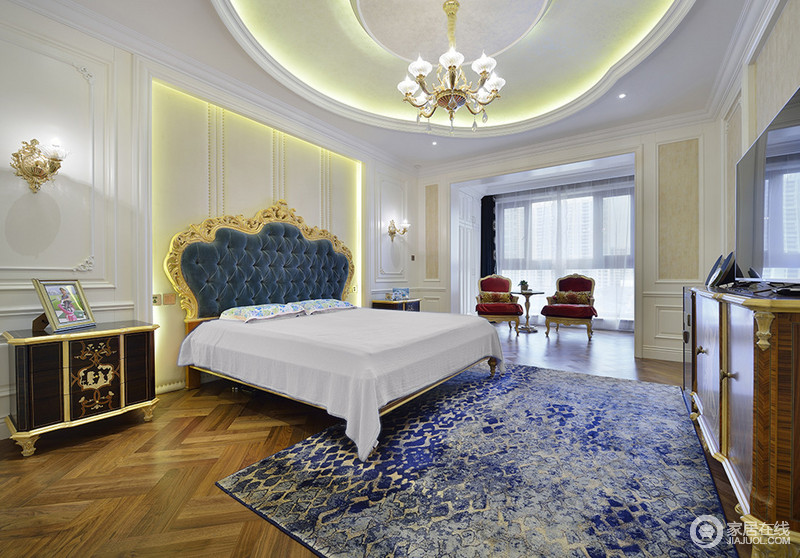 卧室延续了客厅的蓝白色，呈现出端庄大气的空间气质。墙板的凹凸立体质感，与扎染风地毯上的金色线条，相得益彰。阳台上，两把沙发椅配一件边几，优雅的休闲感营造出来。