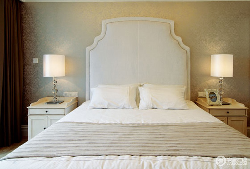 卧室结构规整，整体空间的设计以对称的方式表达出和谐感，床头柜和台灯的复古之美，呼应着高椅背的床头，尽显古典美学，白色床品配上驼色薄毯，让整个空间更为温馨。