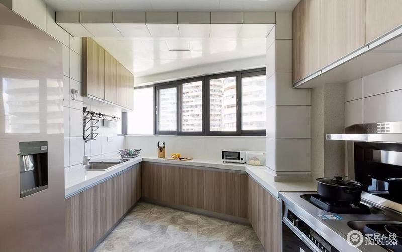 厨房，白色墙砖和浅木色的橱柜，让不规则的空间形态得以视觉上的弱化处理，也使得空间色彩明亮轻快。

