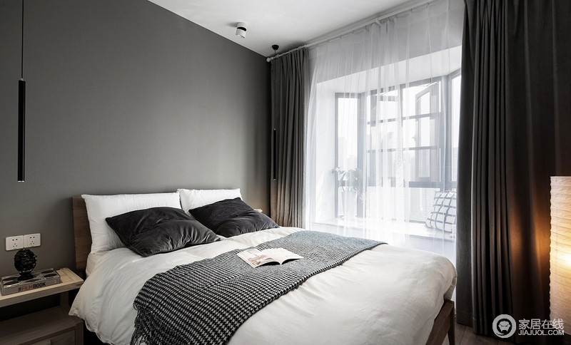 大大的落地窗让卧室光线充足，再加上薄纱的穿透力，为空间抹上一份浪漫；灰色的背景墙十分素静，而白色床品与之形成柔和舒适。