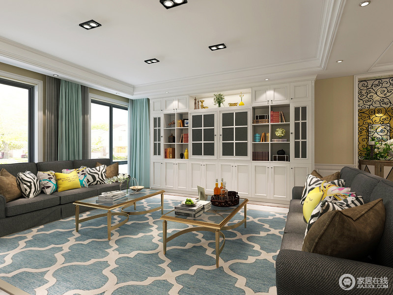客厅里冷静的对称深灰色布艺沙发与迷人浪漫的几何图案蓝白地毯碰撞，在金属玻璃茶几的配合下，带来空间的优雅低奢与舒适悠闲。依墙而设的白色顶面置物柜，增加空间储物功能。