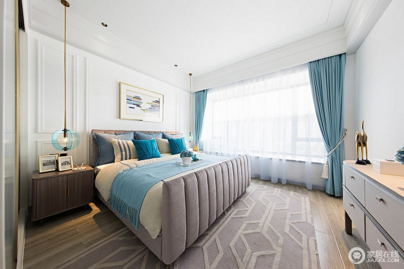 卧室以蓝白相间为主，营造纯净和雅致，尽力缓和空间的沉闷；驼色几何地毯的点缀与褐色实木家具组合，将美观与实用兼并起来，调和出温和与自然舒适之感。