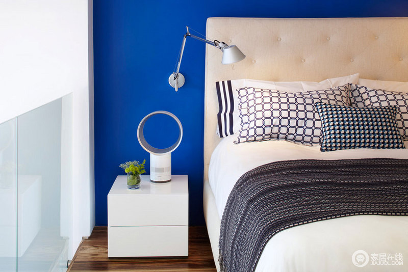 蓝色的床后的墙上，简约的床头装饰。