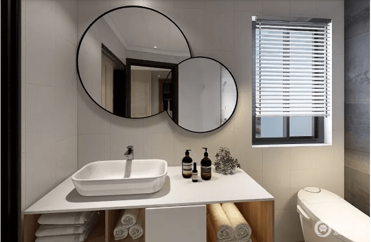 卫生间使用木纹的盥洗柜来增加空间内的暖色调，摩铁金属质感的圆镜与白色盥洗台形成反差，给予空间几何时尚，简单中蕴藏着生活的质感。