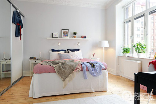 卧室虽然不大，但是对称的床头柜让空间和谐生动；悬挂木板上陈列的挂画和装饰物装饰出简约感，而黑白靠垫给予空间色彩之时，也让生活变得更为舒适。
